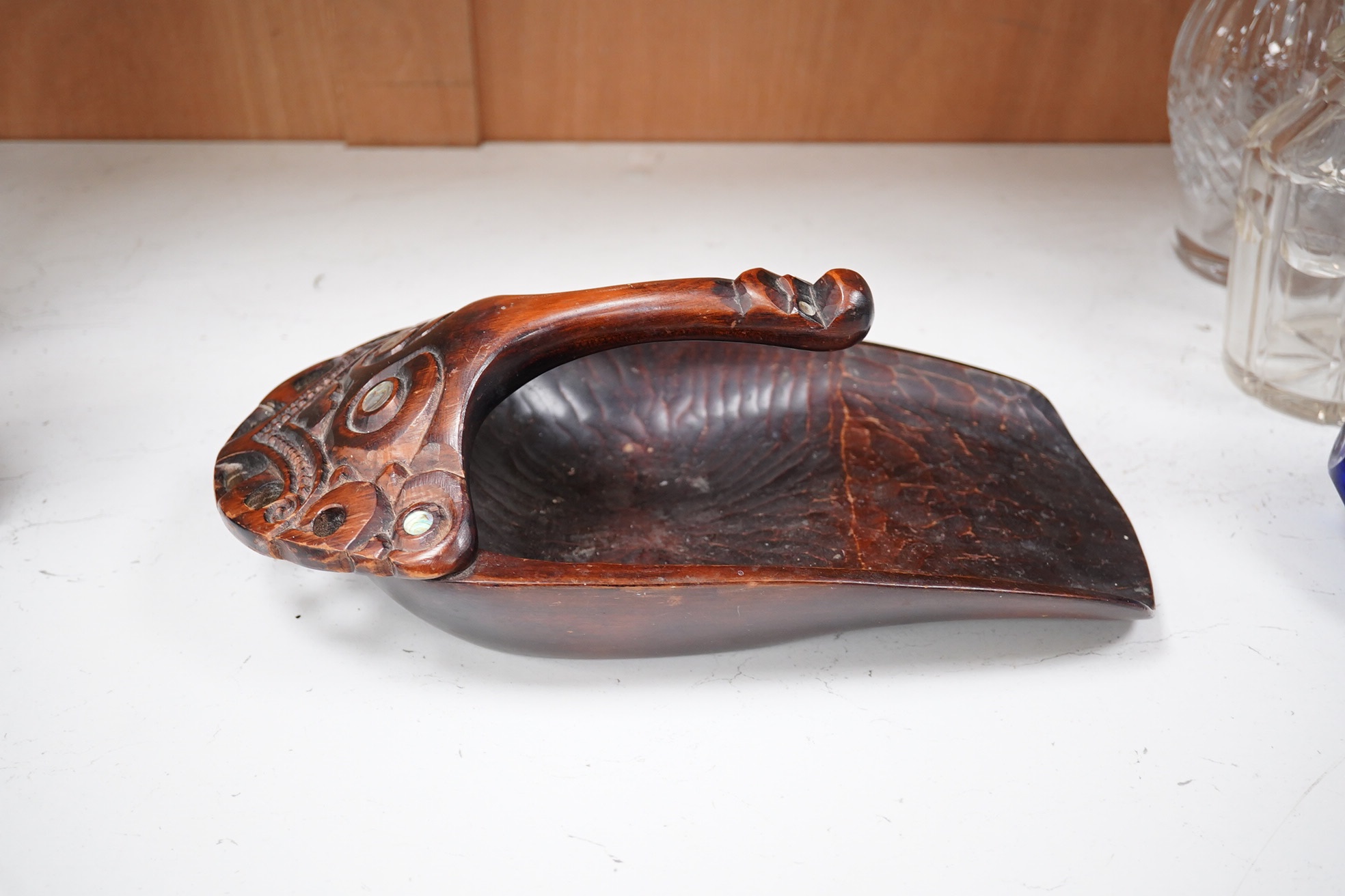 A carved Maori ta ta (water bailer) with mother of pearl inlay, 33cm long. Condition - good